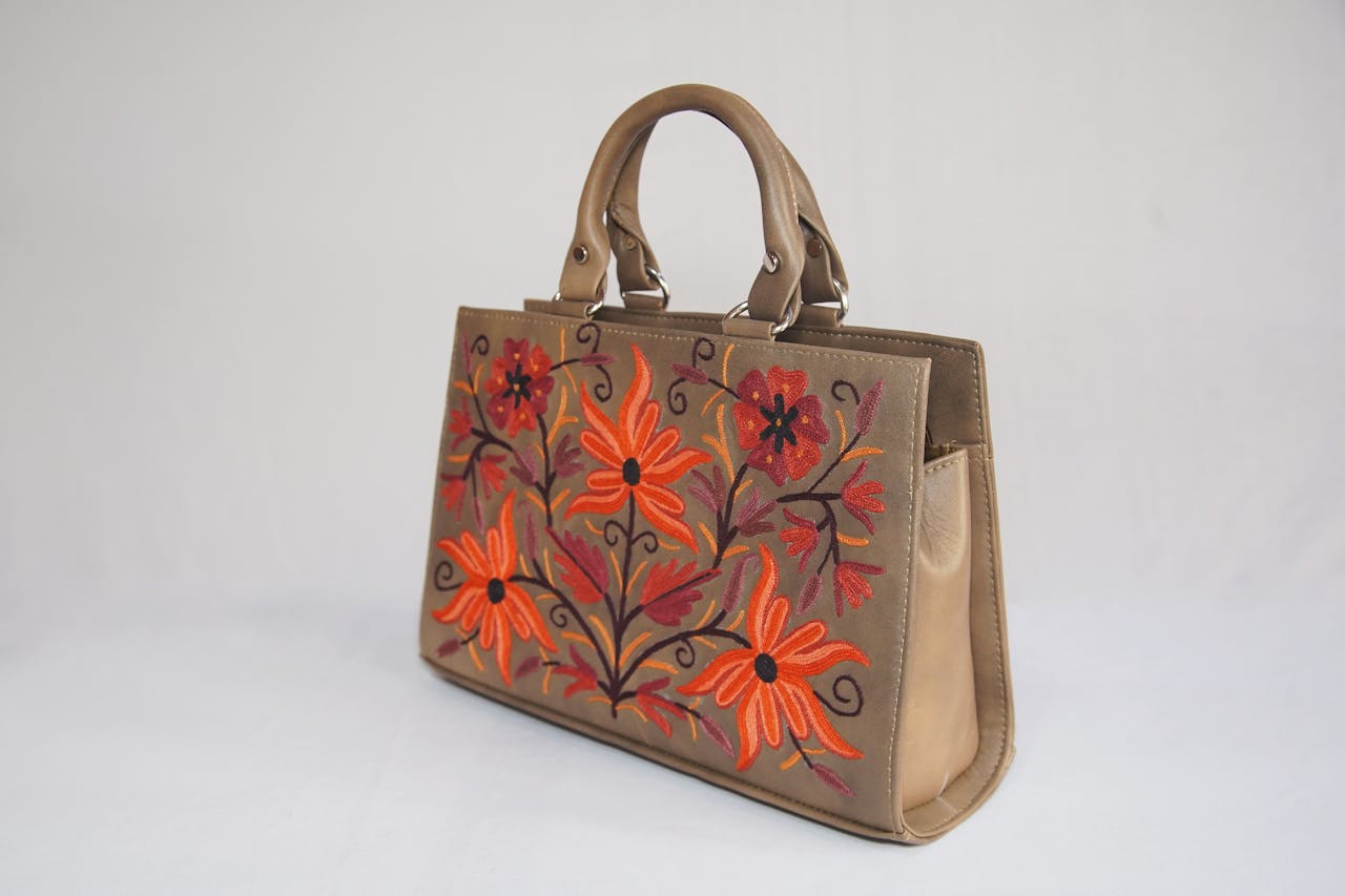 about-01 Stylish handbag with vibrant floral embroidery on a white background, perfect for fashion shoots.
