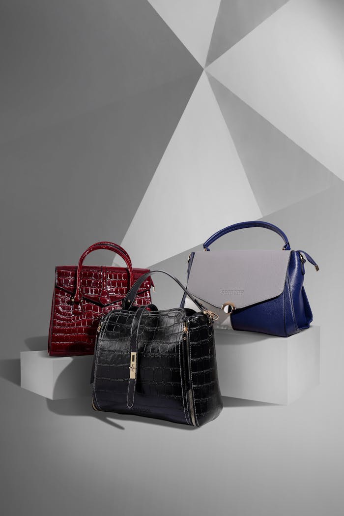 gallery-3 Stylish leather handbags displayed on a geometric studio background.